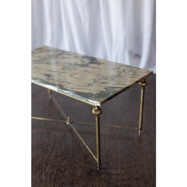 This vintage brass and marble rectangle coffee table pairs an elegantly veined marble top with a refined brass frame,...