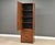 A mid century modern walnut tall dresser armoire with one large door, adjustable shelving and lower drawers made by...