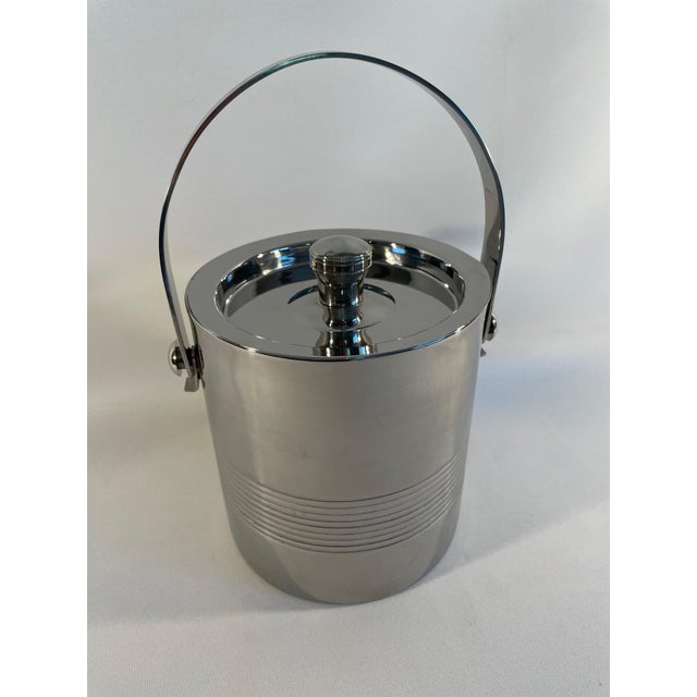 A stunning Vintage Stainless Steel Ice Bucket with a lid and swing handle. Circa Late 20th Century. This beautiful and...