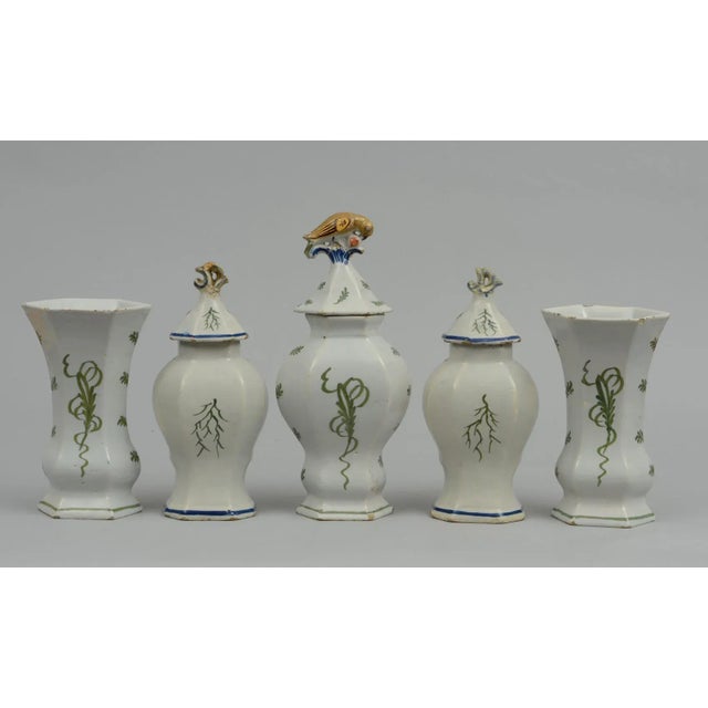 Assembled five-piece Dutch delft vase garniture, all polychrome decorated. Three vases depicting ships, the sea, cliffs...