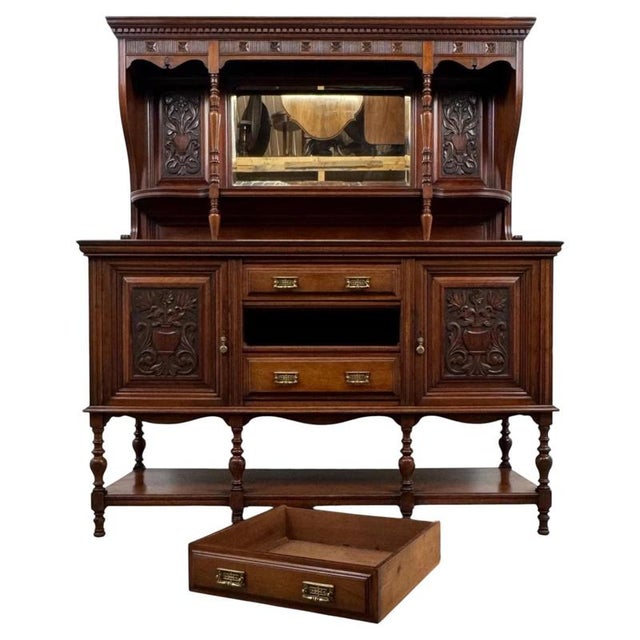 An exceptional early 20th-century English mirror-back sideboard, finely crafted from walnut and distinguished by its...
