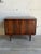 This elegant low-profile sideboard credenza features a streamlined rectangular silhouette elevated by four round tapered...
