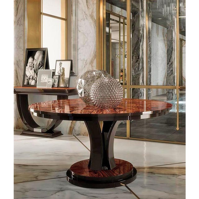 Hand crafted in Italy, this 51" round pedestal dining table features a striking book matched veneer top set against a...