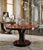 Hand crafted in Italy, this 51" round pedestal dining table features a striking book matched veneer top set against a...