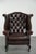 This elegant Chesterfield wing armchair is made of cowhide leather and offers a comfortable seat. The armchair features a...
