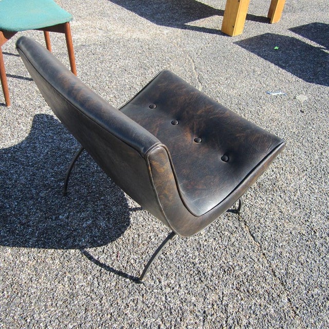 A vintage Mid Century Modern scoop chair by Milo Baughman. Comes upholstered in dark brown leather with a beautiful...