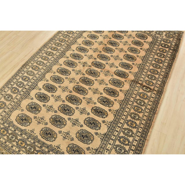 A tribal Bokhara rug hand-knotted with fine wool on a cotton foundation. This rug features rows of repeating medallions...