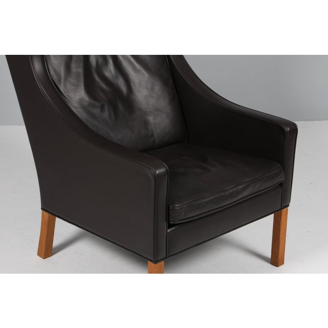 Børge Mogensen wingback chair in original Black leather upholstery. Legs in oak. Model 2204, made by Fredericia Furniture....