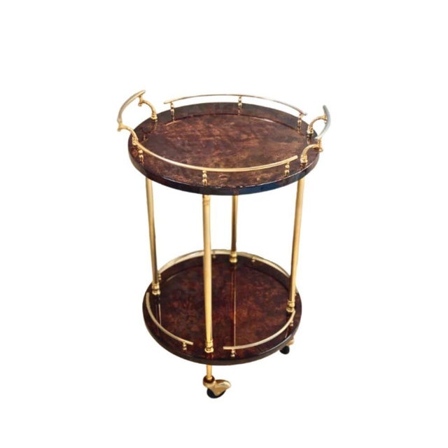 Circa 1960 Hollywood Regency two tier drinks table by Aldo Tura, Milan, Italy. The shelves are lacquered goatskin or...