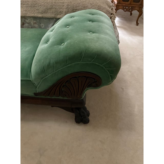 Beautiful Victorian-style fainting chaise lounge featuring classic tufted upholstery, elegant curved back, and carved...