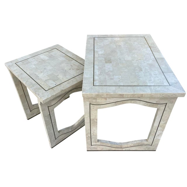 Elegant vintage nesting tables featuring cream marble veneer surfaces accented with thin brass inlay banding. The tables...