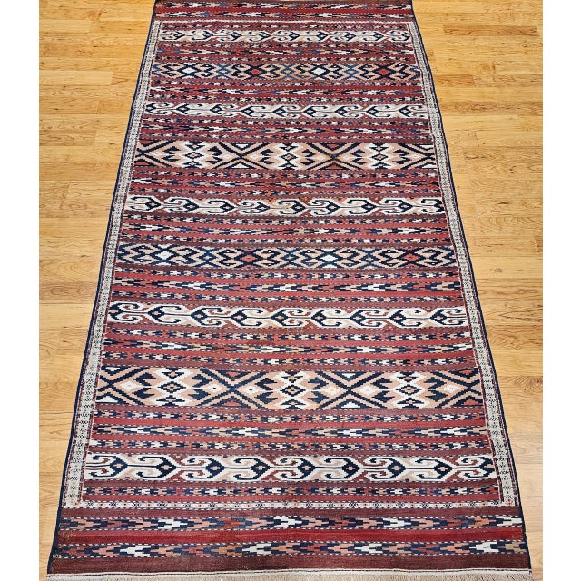 An early 20th century Turkmen Yomut tribal kilim from Central Asia, distinguished by its refined geometric stripe...