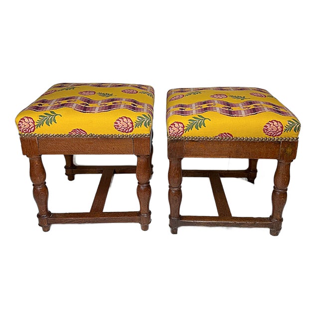 This is a unique pair of antique French, Pierre Frey Upholstered, Louis XIII style oak ottoman stools. They feature a...