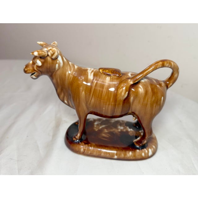 This early antique drip brown glaze Staffordshire pottery cow creamer sculpture is a unique and exceedingly rare piece...