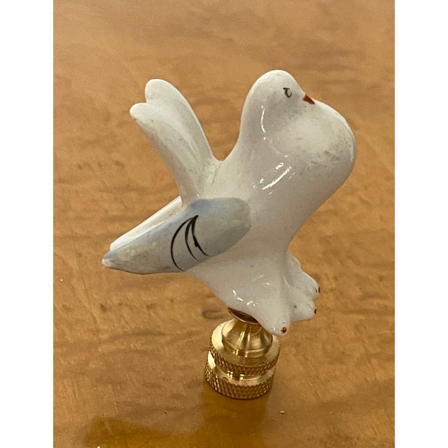 Handmade porcelain figurine of a dove on brass base as lamp finial.