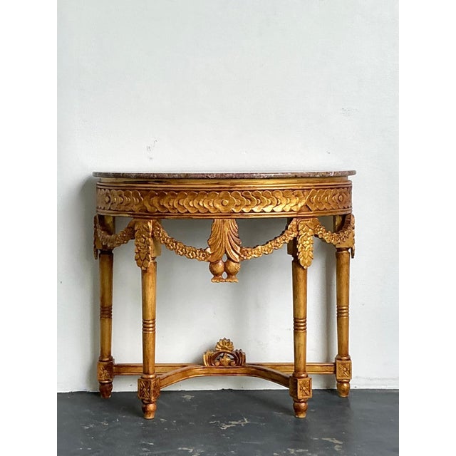 This exquisite antique demilune console table is a masterful example of Continental craftsmanship, blending Neoclassical...