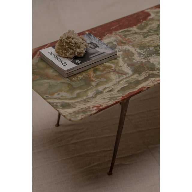 A refined and elegant mid century Italian coffee table, distinguished by its sculptural solid brass base and striking onyx...
