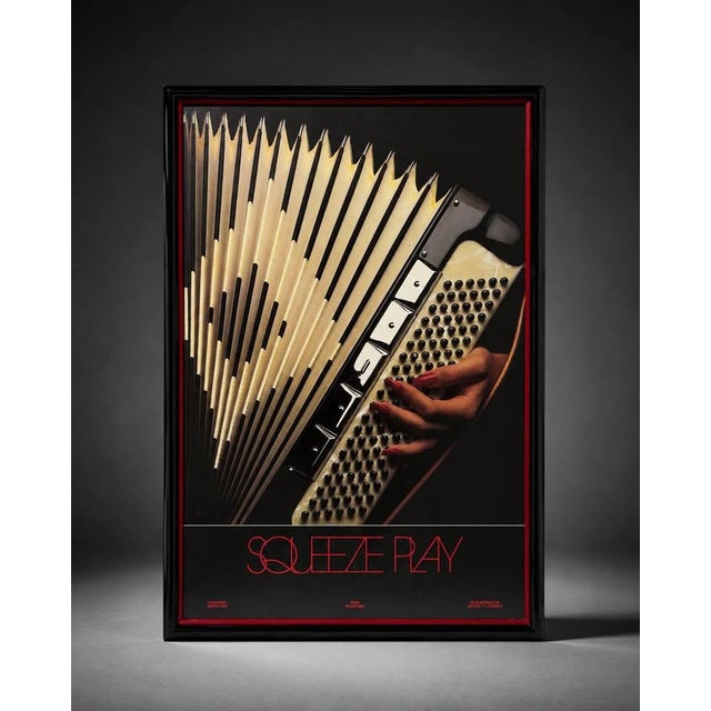 Framed vintage-style poster titled “Squeeze Play” featuring a bold close-up graphic of an accordion being played by a hand...