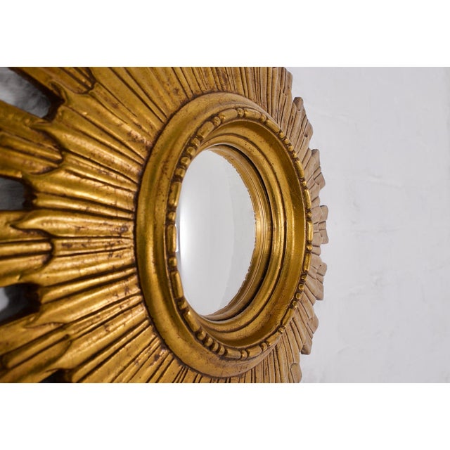 Convex sunburst mirror, also known as a sunburst or witch's eye mirror, made of resin imitating gilded wood. 1960s/1970s....