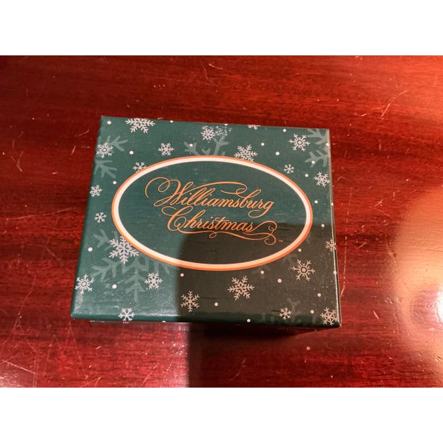 Small, lightweight tree ornaments made of wood, resin or other composite material contents not marked) hang from tree with...