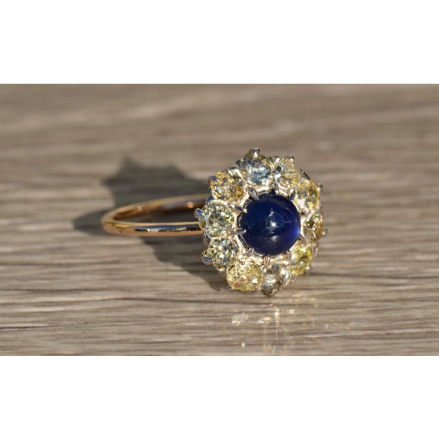 The Tana Antique Mixed Metal Sapphire Cabochon and Old Mine Cut Diamond Halo Ring. Crafted in 14 karat yellow gold and...
