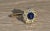 The Tana Antique Mixed Metal Sapphire Cabochon and Old Mine Cut Diamond Halo Ring. Crafted in 14 karat yellow gold and...