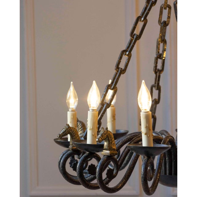 A striking 20th-century French chandelier crafted in wrought iron, distinguished by its sculptural presence and refined...