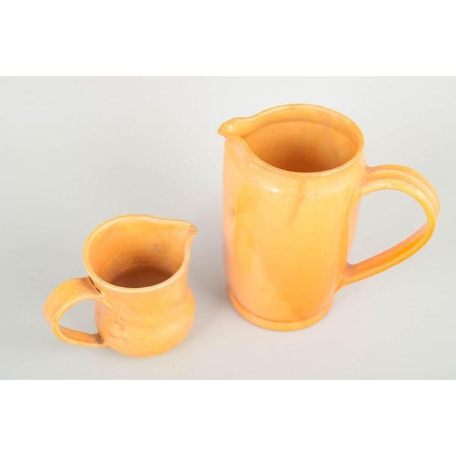 Kähler, Denmark Two large pitchers, 1930s. Two large hand-thrown ceramic pitchers in Kähler’s characteristic yellow-orange...