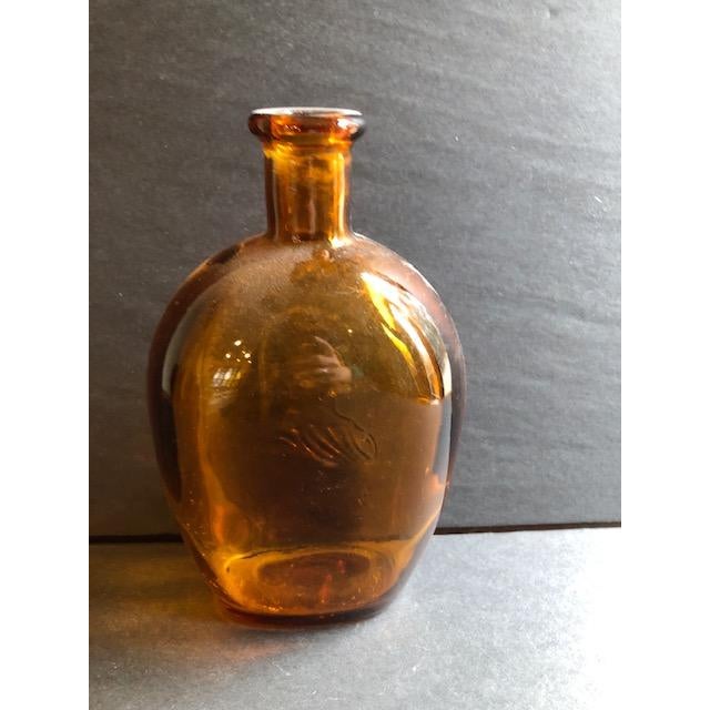 Mid-20th-century amber-colored glass whiskey bottle, featuring the countenance of George Washington - "The Father of His...