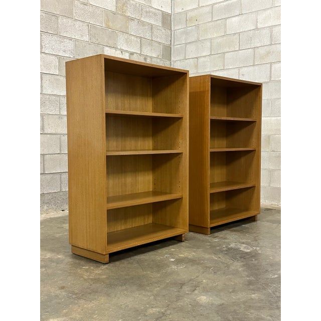 A pair of bleached mahogany bookcases designed by Edward Wormley for Dunbar. Features three adjustable height shelves for...