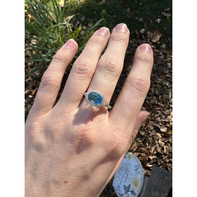 This beautiful ring features a sparkling 4.08 carat blue zircon in 14k white gold and natural earth mined diamond halo. A...
