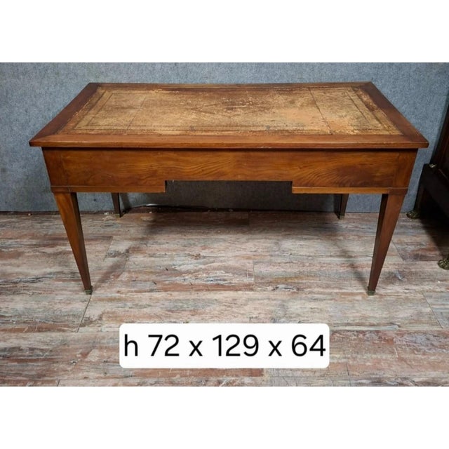 A louis xvi style mahogany flat desk, beautifully understated, with three drawers in the frieze, each adorned with brass...