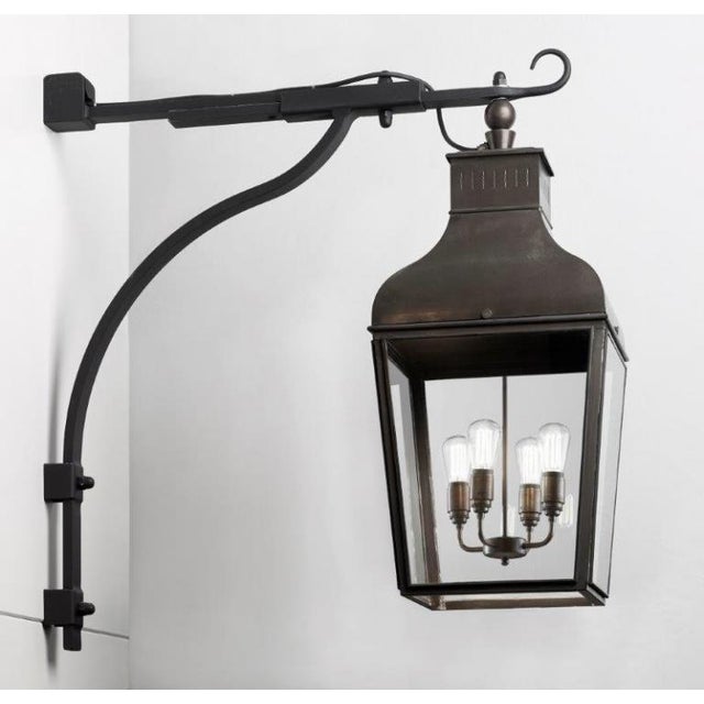 Wall lamp in dark bronze with pagoda structure with outside fitted clear glass and water-resistant cable entry. Provided...