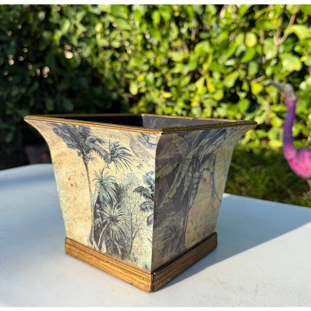 A vintage square cachepot featuring botanical and antique map decoupage with antiqued gold colored trim and a clean,...