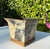 A vintage square cachepot featuring botanical and antique map decoupage with antiqued gold colored trim and a clean,...