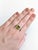 A rare sphene shines in a fiery green-gold at the centre of this solid 14K yellow gold ring, encircled by sixty earth-...