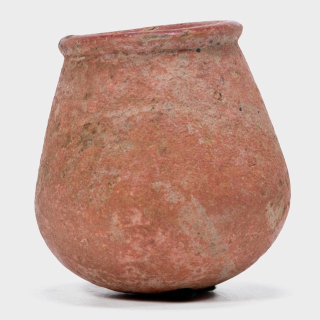 This petite hand-formed vessel bears a richly textured surface of worn red clay slip and dark smoke marks. Likely intended...