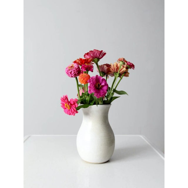 A vintage Wilson Creek studio pottery vase with a hand-crafted form and a soft white glaze. The surface has a quiet,...