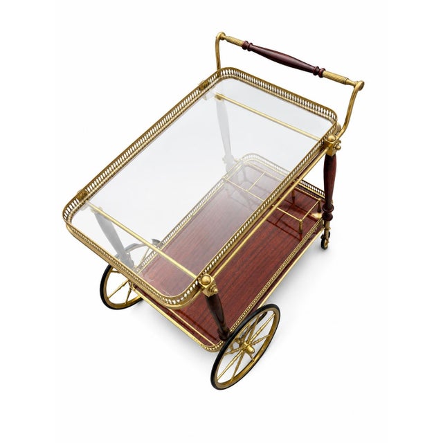 An elegant, sophisticated party trolley in the Hollywood Regency style, reminiscent of the iconic design language of...