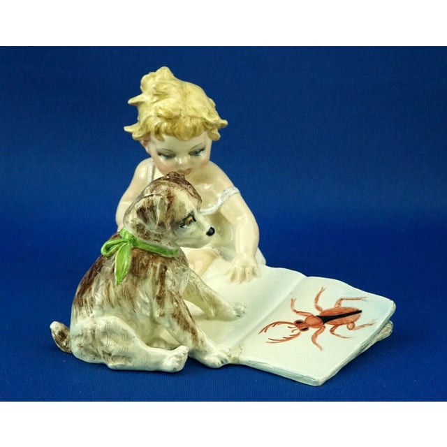 A wonderful sculpture depicting a little girl sitting with a large book and a small dog, made of glazed ceramic (ceramic...