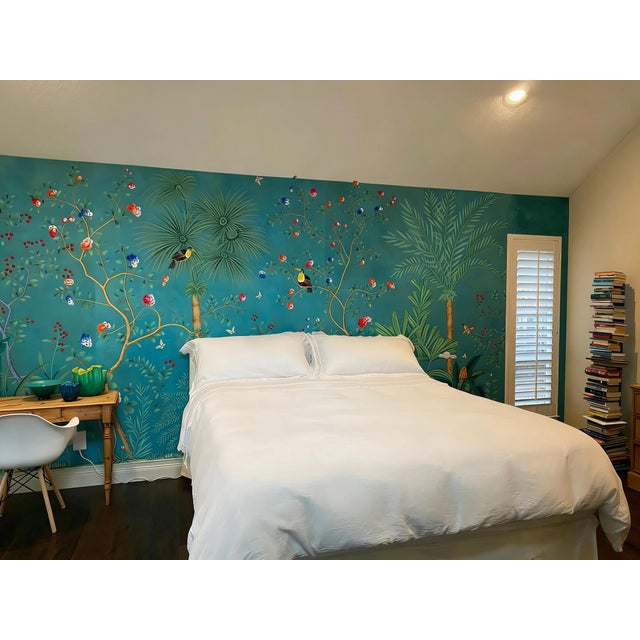 Artisan hand-painted chinoiserie mural with rich teal background, featuring lush tropical palm foliage, blooming colorful...