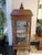 Early 20th century wooden vitrine from Eastern Europe. All four walls in glass with two shelves inside. Floral relief...
