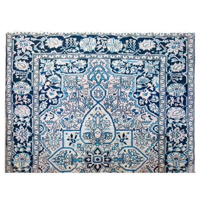A mesmerizing early 20th century Persian Sarouk Farahan rug with a large central floral medallion living amidst a field of...