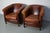 This pair of cognac-colored leather club chairs come from the Netherlands. They are upholstered with patinated cognac-...