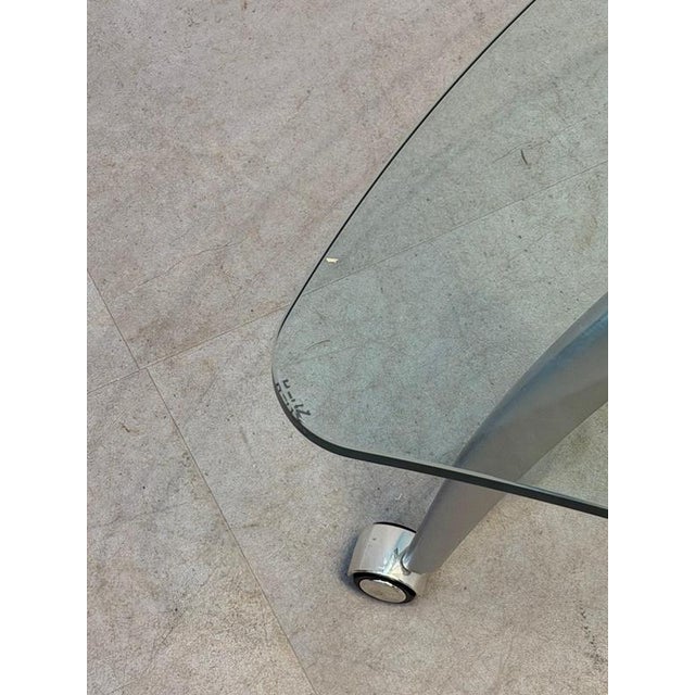 Elegant and modern coffee table by Rolf Benz featuring a thick smoked glass top with soft organic lines. The sculptural...