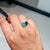 This Toi et Moi ring features 2.66 carats of natural emerald and sapphire, set in 14K white gold each measuring...