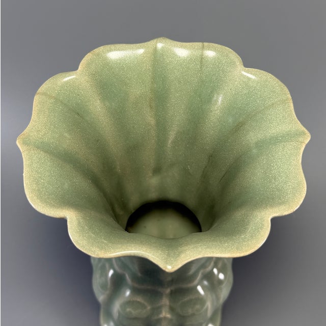 Fine antique Chinese celadon gu‑form vase. Flaring foliate rim, lobed body with carved relief floral ornament, elegant...