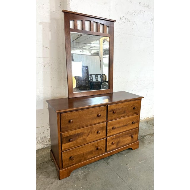 This cherry dresser offers six spacious drawers arranged in two columns, accented with matching wooden knobs and warm,...