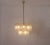 Brass chandelier composed of 13 light arms, each adorned with a curved, molded glass element with a compartmentalized...