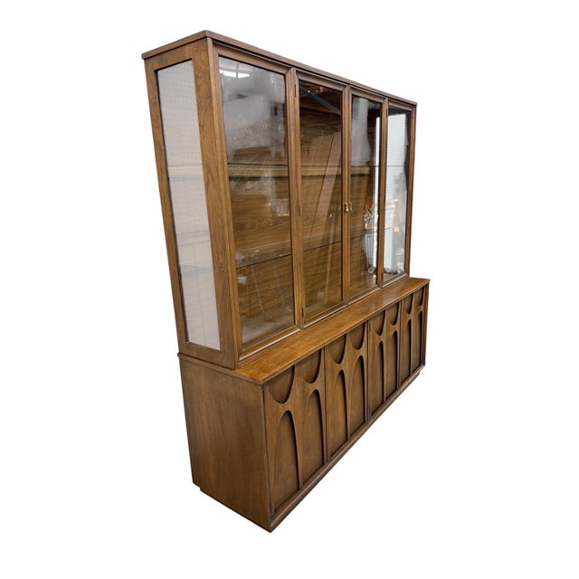 An iconic piece of American Mid-Century Modern design, this Broyhill Brasilia 2-piece walnut china cabinet showcases the...